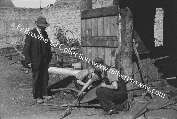 MEN REPAIRING PLOUGH